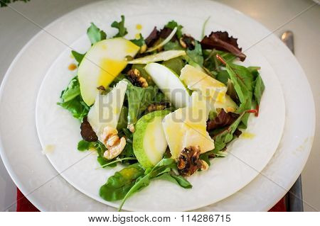 Salad With Pears, Walnuts And Cheese On White Plates