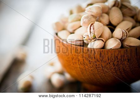 Close-up Of Roasted Pistachios On Wooden Background