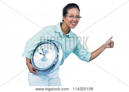 Delighted businesswoman holding a clock against white background