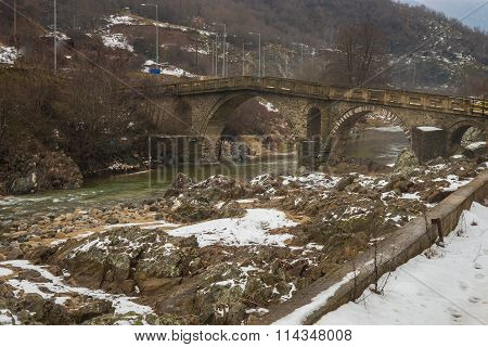 Bridge Across River With Green Waters, Snow And Ice Near Xanthi In Greece