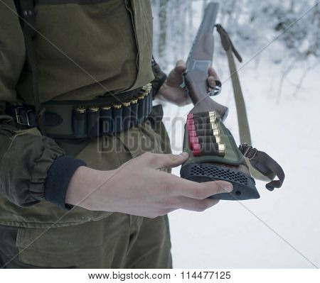 Gun With Cartridge Belt In Hands Of Hunter