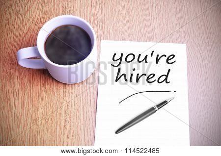 Coffee On The Table With Note Writing You're Hired