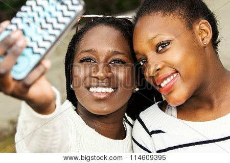 Two African Teens Taking Selfie With Smart Phone.