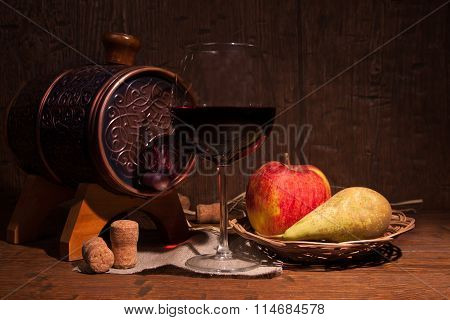 Glass Of Red Wine And Barrel On Rustic Wood Tabel