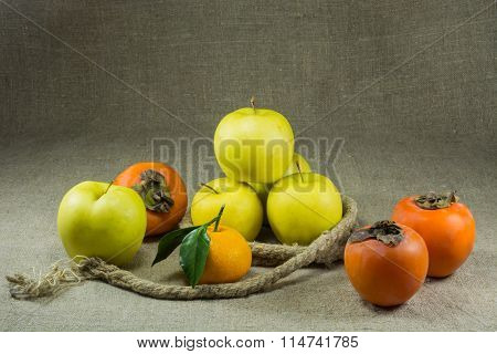 Apples persimmons tangerine on a table