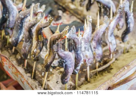Fish with salt being grilled outdoors in Japan