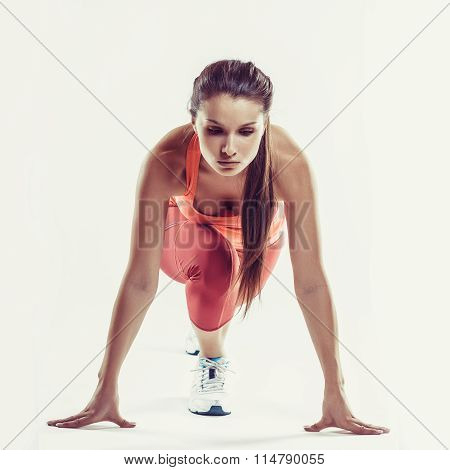 Fit Female Athlete Ready To Run Over Grey Background. Female Fitness Model Preparing For A Sprint