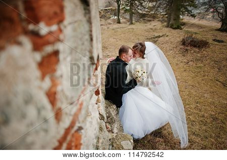 Young Wedding Couple On Winter Background Stone Landskape And Wall Of Old Castle