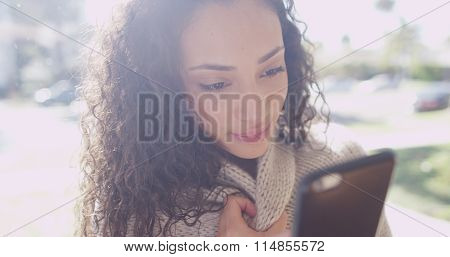 Cute Young Latino Woman Looking At A Cell Phone Device