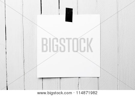 Blank White Poster Hanging On A Tape On White Wooden Plank Wall.