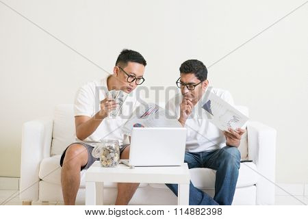 eBusiness concept. Asian men working from home. Young guys counting cash with partner, earning money from their successful online business. 