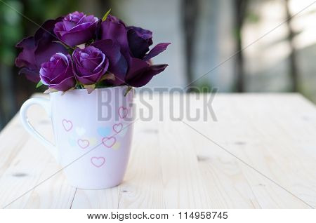 Purple artificial rose in cup drawing heart for love.