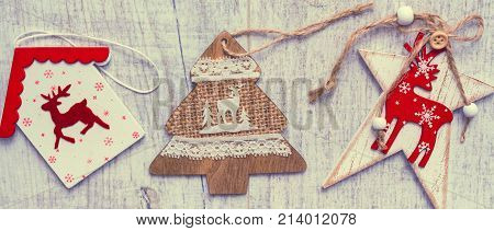 Christmas background. Christmas trees and Christmas decorations are on old light boards. Fir branches. Handmade decorations. Toned image. Space for text.