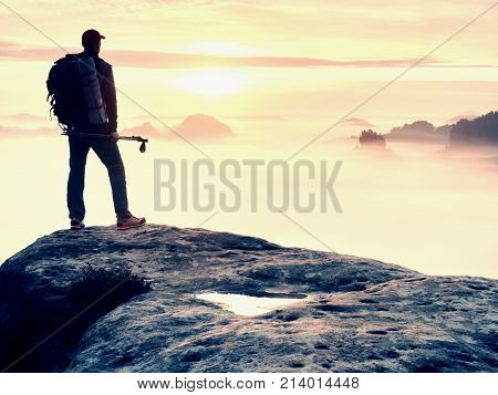 Man Silhouette With Poles In Hand. Sunny Spring Daybreak And Tourist Guide Stay On Sharp Cliff Of Mo