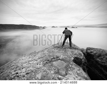 Photographer On The Crater. Man On Peak Above Thick Cloud, Dark Rainy Weather