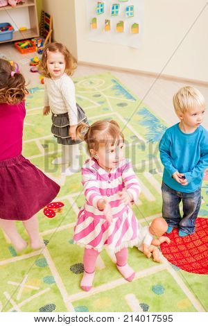 Group of little children dancing and claping in hands