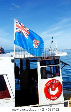 TAVEUNI FIJI - NOVEMBER 29: National flag of Fiji flying on a small boat docked at Korean Wharf on November 29 2013 on Taveuni island Fiji. Taveuni is the third largest island in Fiji.