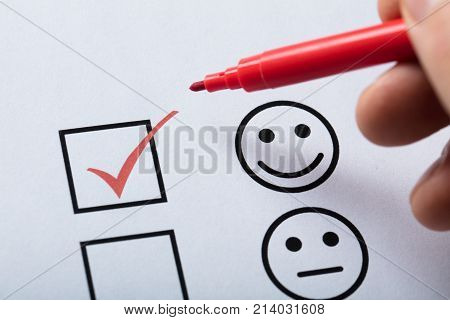 Person's Finger With Pen Over Customer Service Satisfaction Survey Form