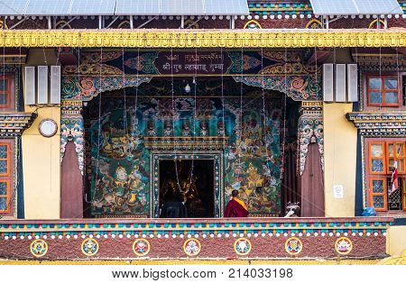 Kathmandu, Nepal - 06 October 2017: Well-designed entrance to the Boudhanath Stupa, Kathmandu, Nepal. Monk prays near the entrance alone.