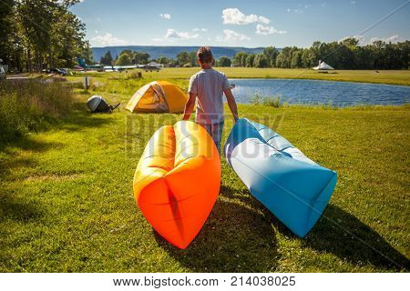 Man walking with Inflatable sofas out in the wild camping