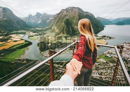 Couple Man and Woman follow holding hands in Norway mountains Love and Travel happy emotions Lifestyle concept. Young family traveling active adventure vacations Rampestreken aerial view