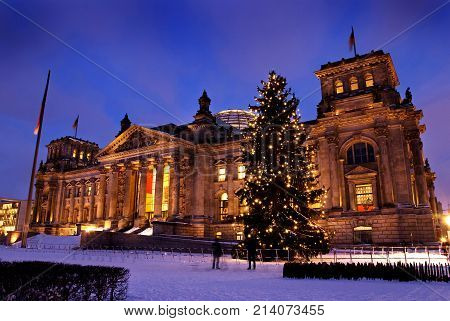 Reichsatag Building In Winter With Christmas Tree And Snow In Berlin