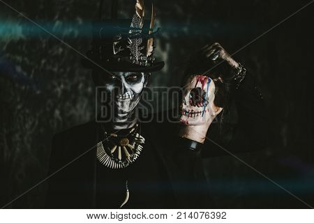 A man with a skull makeup dressed in a tail-coat and a top-hat. Baron Saturday. Baron Samedi. Dia de los muertos. Day of The Dead. Halloween.