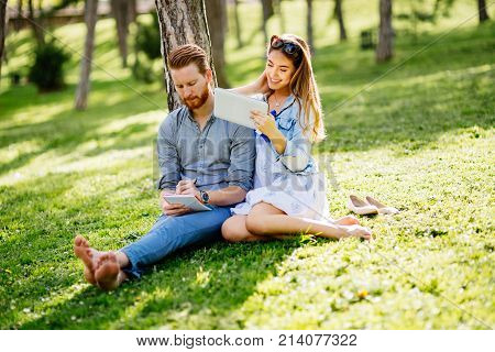 Beautiful couple studying together for exams in nature
