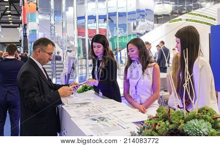 St. Petersburg, Russia - 3 October, Businessman and girl standistas behind the counter, 3 October, 2017.
Participants and visitors of the annual St. Petersburg Gas Forum.