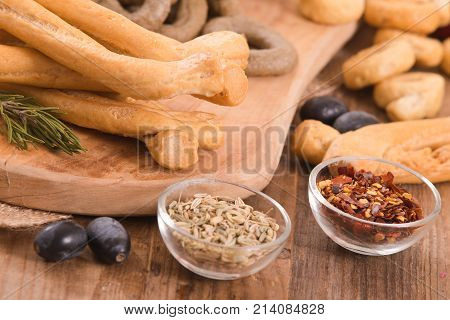 Italian taralli with spices and olive oil on cutting board.