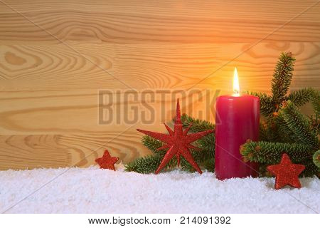 Avent candle and christmas decoration isolated on wood background. Christmas background with snow, candle and red stars.