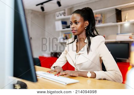 Black businesswoman using computer in office and typing on keyboard