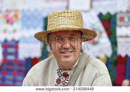 Belarus, the city of Gomel, June 3, 2017. Independence Day in Belarus.A man in a straw hat braids from a vine.Products from straw. Ethnic handicraft. Man master of straw