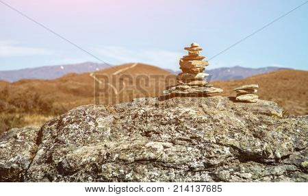 Stack of stones covered with moss on top of the mountain