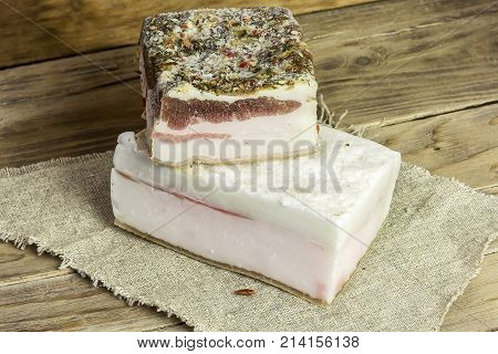 Rustic salted lard lies on a napkin on a wooden surface
