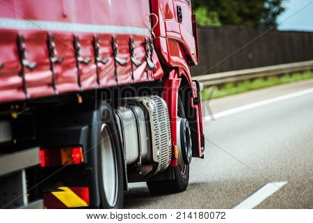 Red Speeding Semi Truck on the European Highway. Transportation Industry.