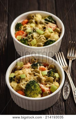 Casserole with vegetbales and cheese on wooden background..