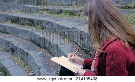 Attractive Young Female Student Preparing For Lectures In University While Sitting On The Stairs, Wr