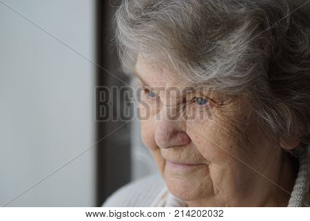 Portrait of smiling mature elderly woman aged 80s indoors. Close-up