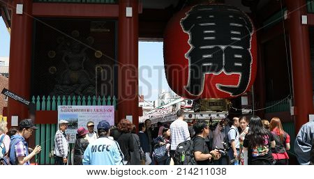 Tokyo, Japan - April 19, 2017: crowded people in front to red giant lantern of Kaminarimon Gate in Senso-ji, the oldest temple in Tokyo, Asakusa. The Japanese word on the lantern means THUNDER GATE.