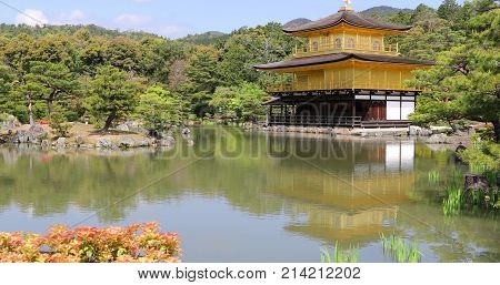 Scenic landmark Kinkakuji or Rokuonji, Unesco site of Kyoto, reflected on lake.The Golden Pavilion, whose top two floors are completely covered in gold leaf, is a ancient Zen temple. Day light shot.