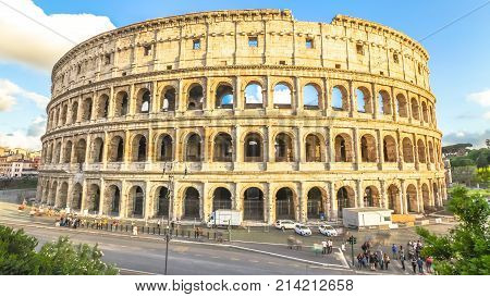 Sunset traffic and tourists moving in front of Colosseum, Colosseo, Flavian Amphitheatre, the largest amphitheater in the world and one of the symbols of Italy and Rome