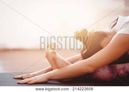 Yoga Concept. Close up woman meditates while practicing yoga in training hall or home.