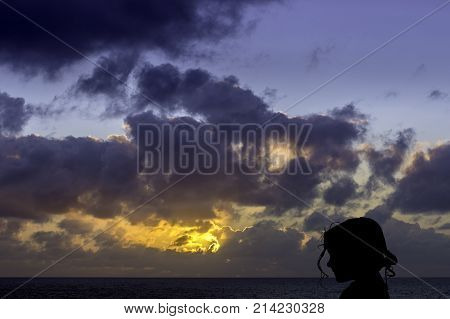 Silhouette of a young girl with sunrise over the ocean in background - Los Cocoteros, Lanzarote, Canary Islands, Spain