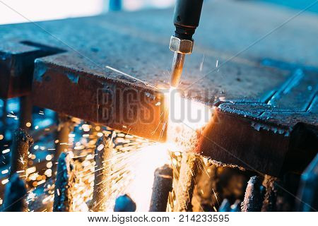 Oxygen torch cuts steel sheet. CNC gas cutting machine. Bright sparks of melting metal