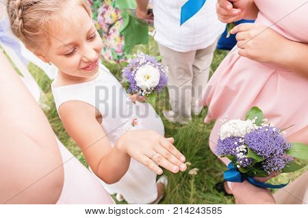 Little sweet girlfriend of the bride brags to her rings to adult girlfriends on the exit registration