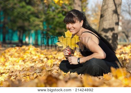 สาวในป่ายิ้ม และถือใบไม้เมเปิล