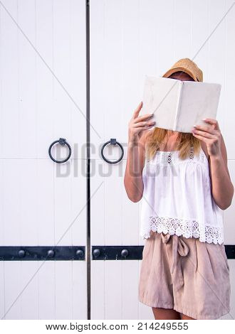 Girl Reading A Book At The Door