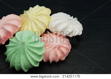 Coloured Meringue on bBack Background. Sweet Dessert