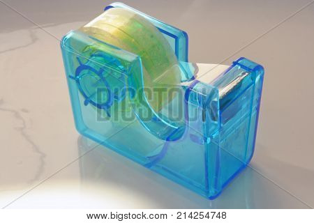 Blue plastic adhesive tape holder. Adhesive tape.